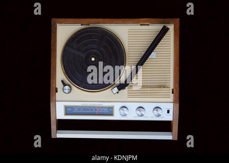 Vecchia radio-fonografo. piatto c, tonearm, la radio am dial, pulsanti e interruttori. La radio-grammofono è isolato su sfondo nero. Foto Stock