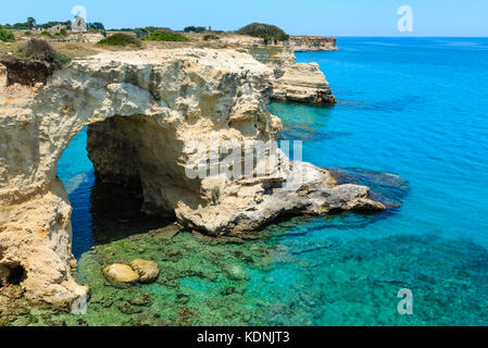 Il pittoresco paesaggio marino con scogliere, arco roccioso e pile (faraglioni), a torre sant Andrea, mare salentino costa, puglia, Italia Foto Stock