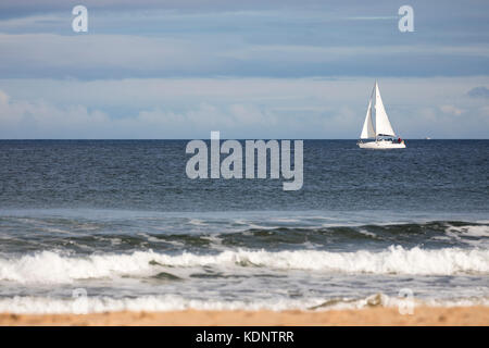 Yacht a vela su un mare calmo nella località costiera di Lossiemouth, Scotland, Regno Unito Foto Stock