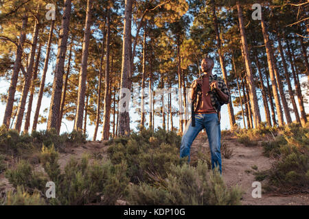 Giovane africano in piedi su un sentiero nella foresta Foto Stock