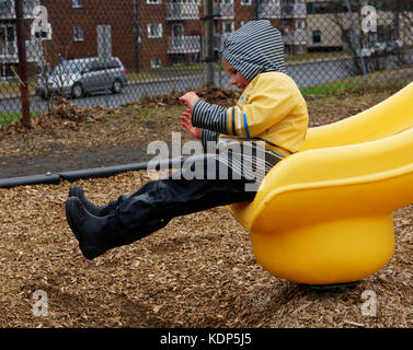 Un piccolo ragazzo (5 anni) sfilamento di una diapositiva in un parco. Foto Stock