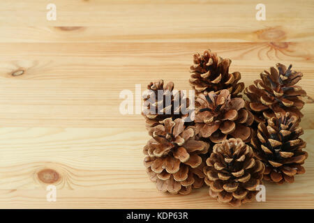 Molti di Natural dry pigne sul marrone chiaro Tavolo in legno con spazio libero per il testo o per la progettazione Foto Stock