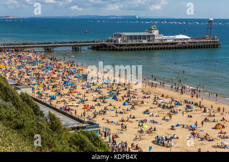 Il molo di Bournemouth e la spiaggia piena di lucertole da mare in una giornata di sole in agosto.Gli aghi sull'isola di Wight può anche essere visto,Bournemouth Inghilterra REGNO UNITO Foto Stock