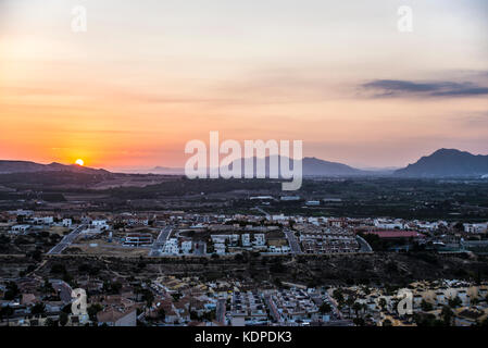 Il sole tramonta dietro le montagne oltre Benijofar, Spagna. Città spagnola della Costa Blanca Foto Stock