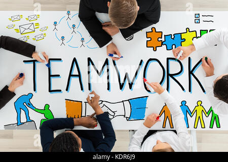Angolo di alta vista di imprenditori disegno del lavoro di squadra concetto sulla scrivania in ufficio con marcatori colorati Foto Stock