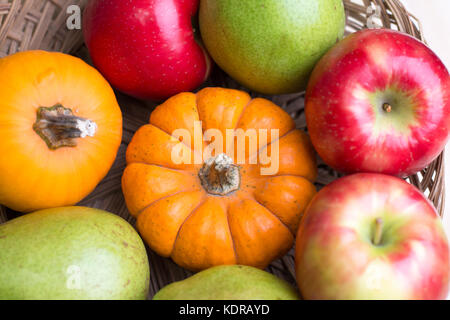 Raccolto autunnale di mela, pera e zucca in un paniere insieme per un centrotavola a una caduta tavolo per la cena. Foto Stock