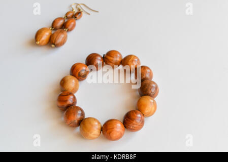 Fatte a mano braccialetto e orecchini in legno d'ulivo, isolato su sfondo bianco Foto Stock
