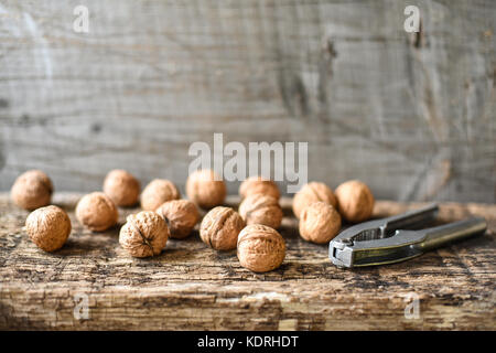 I dadi di deliziosi e schiaccianoci su un vecchio tavolo di legno, la composizione, copyspace Foto Stock