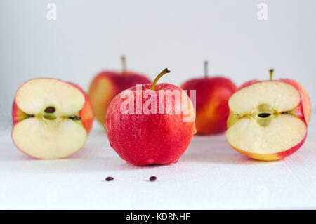 Mature mele rosse con gocce di acqua su sfondo bianco close up Foto Stock