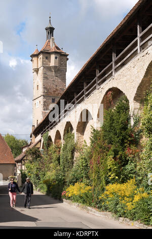 Giovane camminando accanto alle mura della città, Rothenburg ob der Tauber, Baviera, Germania, Europa Foto Stock