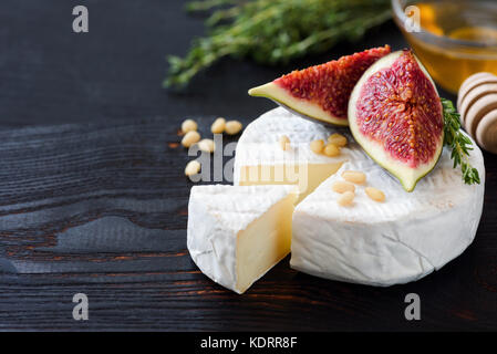 Bianco Formaggio Brie o camambert. antipasto gourmet il piatto di formaggi con formaggio bianco, fichi, timo, miele e noci Foto Stock