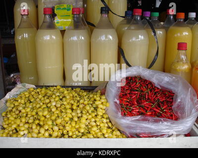 Ver-o-mercato in pesos, rosso e giallo chilis e bottiglie di pianura tucupi Foto Stock