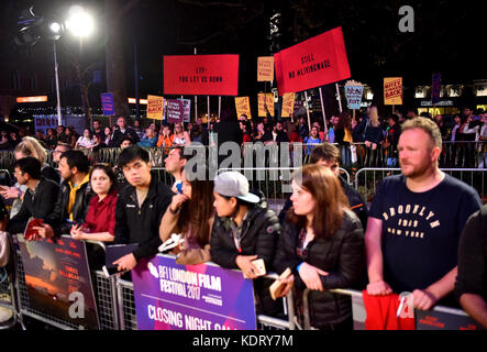 I manifestanti con i cartelli che leggono 'LFF - You Let US Down' e 'No #LivingWage' nella folla alla prima di tre tabelloni fuori Ebbing, Missouri, al gala di chiusura del BFI London Film Festival, presso l'Odeon Leicester Square, Londra. Foto Stock