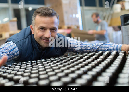 Uomo in impianto di imbottigliamento Foto Stock