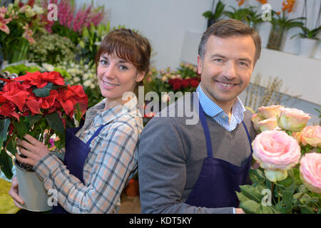 Maschio e femmina fioristi nel negozio di fiori Foto Stock