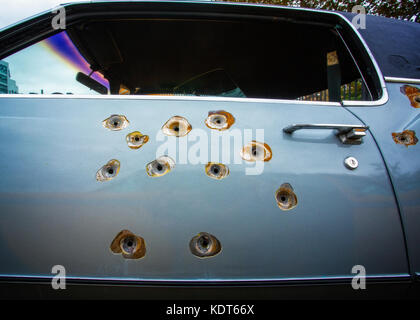 Fori di proiettile in una Cadillac porta auto Foto Stock