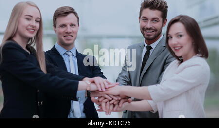 Un gruppo di persone di affari di mettere le mani sulla parte superiore di ogni altri Foto Stock