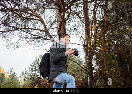 Giovane fotografo fotografare nella foresta di autunno Foto Stock