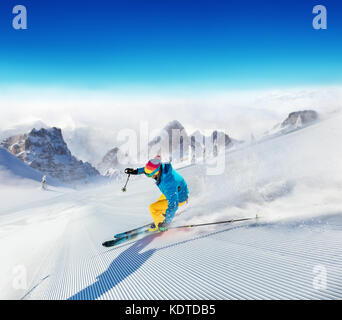 Giovane sciatore correndo giù per il pendio in montagne alpine. inverno sport e ricreazione, leasure attività all'aperto. Foto Stock