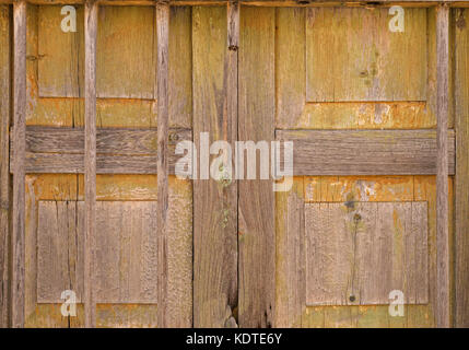 Vecchio pannellata porta di legno,sbiadito e stagionato, nella necessità di manutenzione, barre di legno,sfondo con nessun popolo e spazio di copia Foto Stock