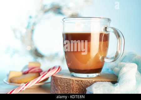 Tazza di vetro di cioccolata calda a bere con il latte su fondo azzurro con bokeh di fondo per natale Foto Stock