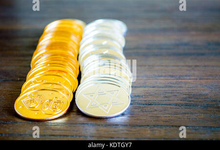 2 righe parallele di oro e argento hanukkah monete su un marrone tavolo in legno Foto Stock