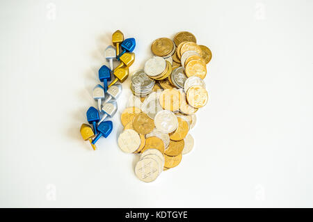 Pila di colorati e dreidels hanukkah monete isolato su bianco Foto Stock
