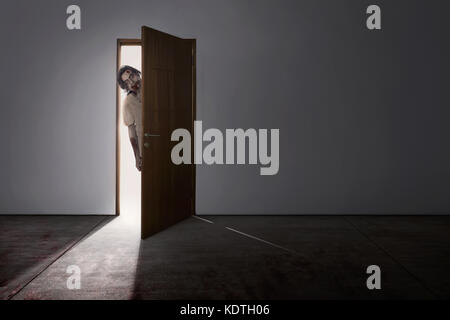 Scena di orrore di zombie asiatici uomo venire su di una porta per la camera oscura Foto Stock