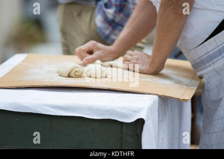 Asti, Italia - 10 settembre 2017: donna bussa e forme di farina per fare il pane Foto Stock