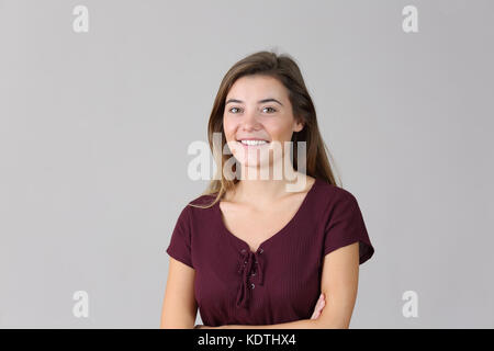 Ritratto di un felice teen ragazza guardando si è isolato su sfondo grigio Foto Stock