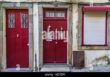 Porte rosse di una casa sulla strada freccia nel quartiere Ribeira nella parte vecchia della città di Porto sulla penisola iberica, seconda città più grande in Portogallo Foto Stock