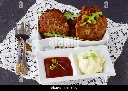 Uova fritte frittelle di vegetali con pomodoro e salsa di yogurt in una ciotola bianco su un grigio Sfondo astratto. cibo sano. una sana prima colazione. Foto Stock