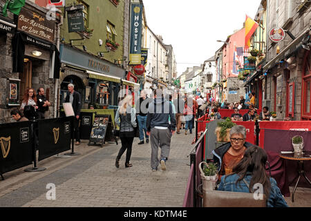 D'estate su Quay Street a Galway, l'Irlanda è piena di ristoranti, bar e aziende che aprono spazio all'aperto ai turisti e alla gente del posto. Foto Stock