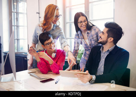 Un gruppo di giovani progettisti in prospettiva di discutere in ufficio Foto Stock