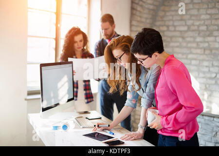 Un gruppo di giovani architetti con tavoletta digitale Foto Stock