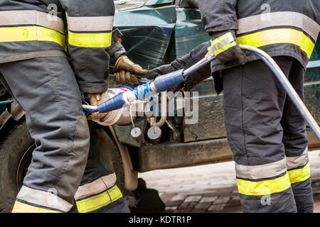 Zamość/POLONIA - agosto 13,2017: vigili del fuoco lavorando su un veicolo automatico extrication con una potenza idraulica strumento di salvataggio Foto Stock