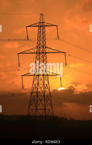 Bedfordshire, Regno Unito. Il 16 ottobre 2017, UK Meteo, elettricità tralicci resistere alle alte velocità del vento durante la tempesta Ofelia come golden sun imposta vicino a Luton, Bedfordshire, England Regno Unito. Foto Stock