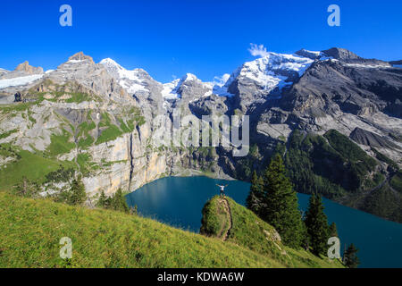 Escursionista ammira il lago oeschinensee Oberland bernese kandersteg cantone di Berna in Svizzera Europa Foto Stock