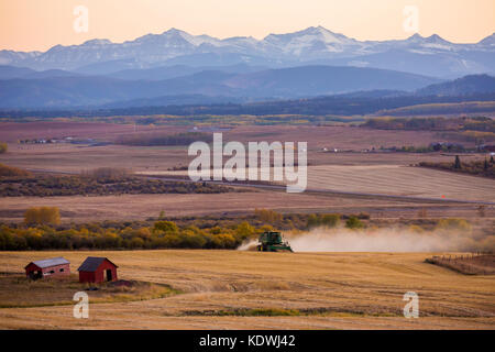 Le nuvole catturano il tramonto sopra le colline pedemontane a ovest di Calgary, dove vengono raccolti i campi. Foto Stock