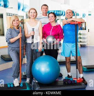 Donne e uomini anziani con sfere di fitness e manubri in una palestra Foto Stock