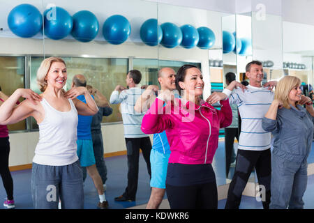Positiva la gente sorridente formazione in una palestra facendo pilates Foto Stock
