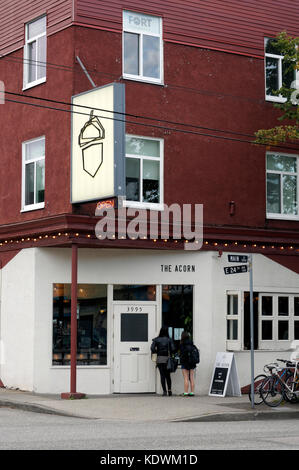Due giovani donna leggendo il menu al di fuori del Acorn vegetariane e vegane ristorante su Main Street, Vancouver, BC, Canada Foto Stock