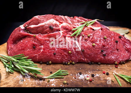Materie carne di manzo tagliata a metà su marrone carta kraft, close up Foto Stock