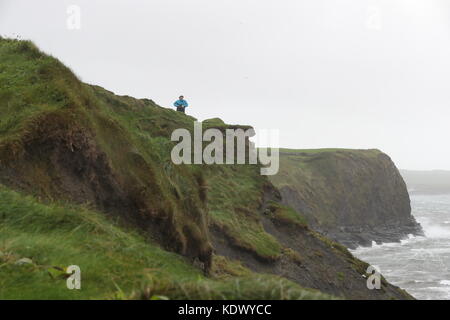 La gente guarda le onde e sea spray a lahinch nella contea di Clare sulla costa occidentale dell'Irlanda come uragano ofelia colpisce il Regno Unito e l'Irlanda con raffiche fino a 80km/h. Foto Stock