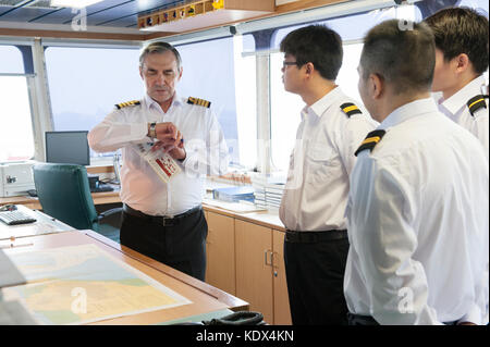 Il capitano e gli ufficiali di discutere i piani di navigazione a bordo di una nave mercantile Foto Stock