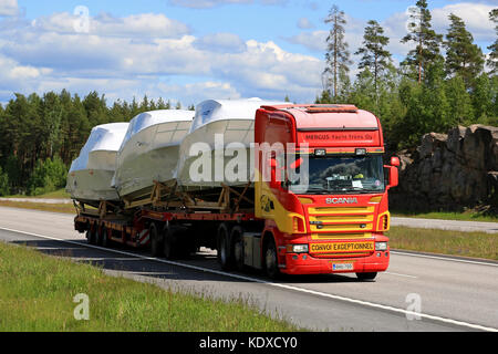 PAIMIO, FINLANDIA - 12 GIUGNO 2016: Scania R420 trasporta semi-imbarcazioni come carico sovradimensionato lungo l'autostrada nel sud della Finlandia. Foto Stock