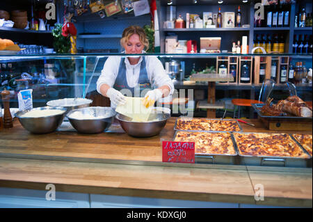 Donna preparare lasagne al Mercato Centrale di Firenze, Italia Foto Stock