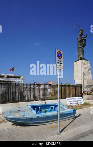 Una barca blu, un non-simbolo di parcheggio e una statua religiosa in Trapani. Da una serie di foto di viaggio in Sicilia, Italia. photo Data: venerdì, 29 settembre 2 Foto Stock