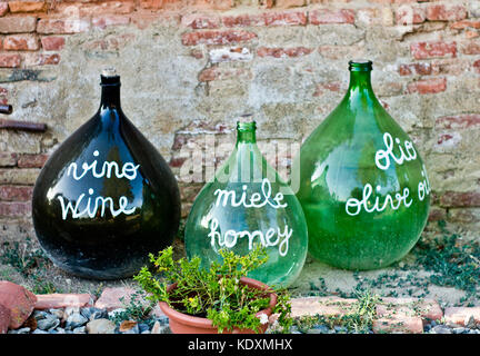 Vecchie bottiglie di vetro grandi utilizzati per pubblicizzare i prodotti dell' agricoltura, olio, vino e miele Foto Stock