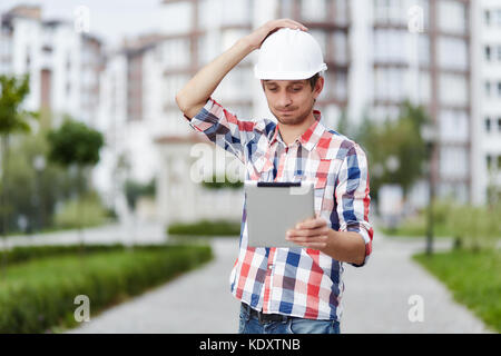 Giovane architetto di fronte all edificio di appartamenti Foto Stock